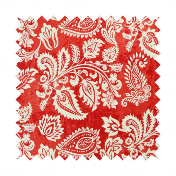 Fabric featuring an ornate repeating pattern of elegant ivory paisley motifs and botanical flourishes over a textured, mottled crimson red background.