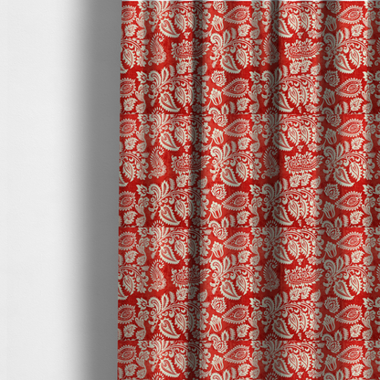 The fabric used to create these made-to-measure curtains is a featuring an ornate repeating pattern of elegant ivory paisley motifs and botanical flourishes over a textured, mottled crimson red background.
