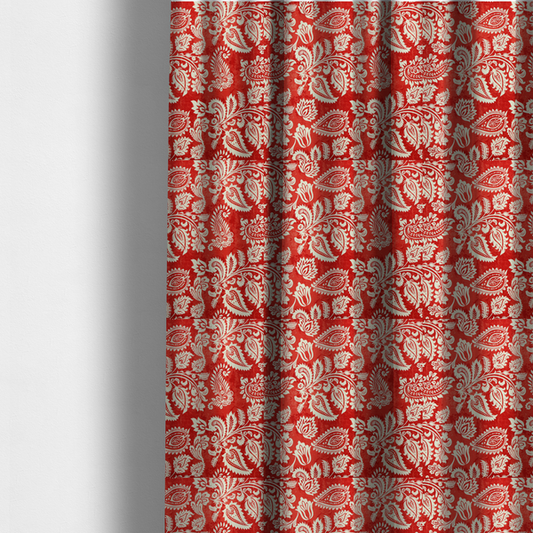 The fabric used to create these made-to-measure curtains is a featuring an ornate repeating pattern of elegant ivory paisley motifs and botanical flourishes over a textured, mottled crimson red background.