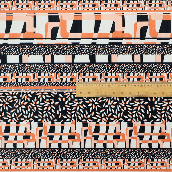 Fabric featuring a bold, multi-patterned horizontal striped design with alternating bands of geometric coral and cream blocks and dense black-and-white micro leaf speckles.