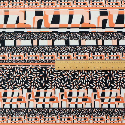 Fabric featuring a bold, multi-patterned horizontal striped design with alternating bands of geometric coral and cream blocks and dense black-and-white micro leaf speckles.
