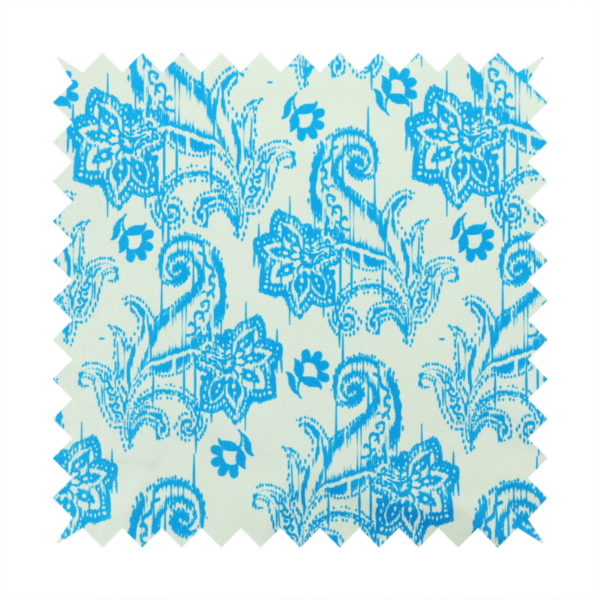 A bohemian-style textile featuring a bold ikat paisley pattern printed against a crisp off-white backdrop. The repeating motif showcases large, ornate teardrop paisley swirls integrated with stylized damask flowers.