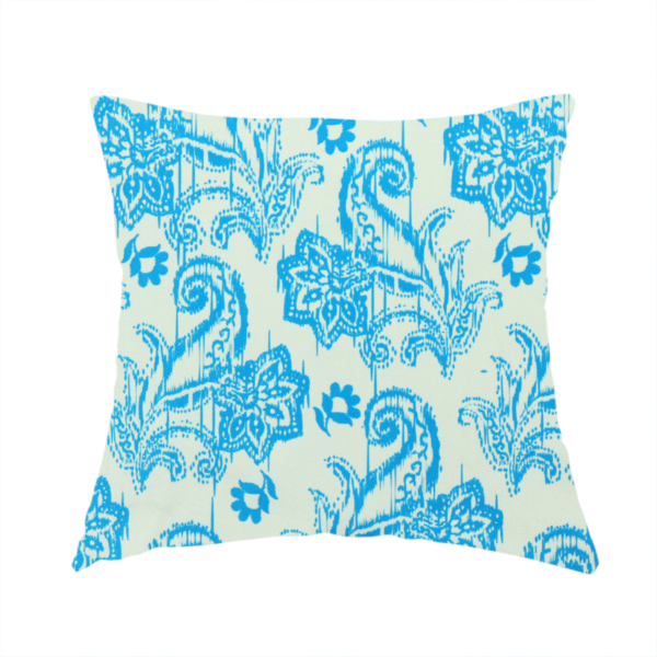 The fabric used to create this handmade cushion is a bohemian-style textile featuring a bold ikat paisley pattern printed against a crisp off-white backdrop. The repeating motif showcases large, ornate teardrop paisley swirls integrated with stylized damask flowers.