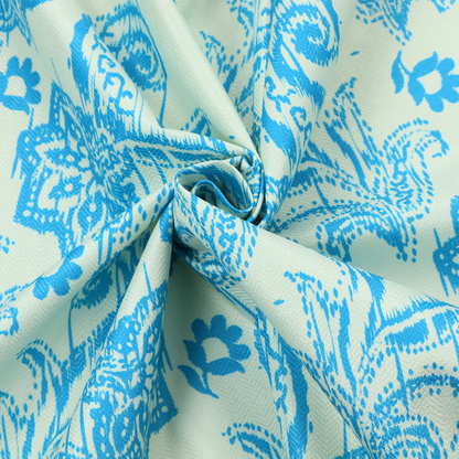 A bohemian-style textile featuring a bold ikat paisley pattern printed against a crisp off-white backdrop. The repeating motif showcases large, ornate teardrop paisley swirls integrated with stylized damask flowers.