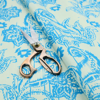 A bohemian-style textile featuring a bold ikat paisley pattern printed against a crisp off-white backdrop. The repeating motif showcases large, ornate teardrop paisley swirls integrated with stylized damask flowers.