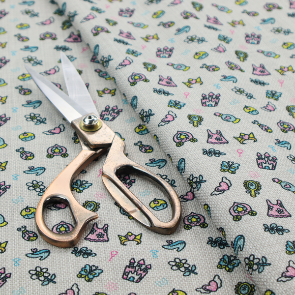 Fabric featuring a whimsical, miniature repeating pattern of pastel princess-themed doodles—including castles, carriages, and crowns—on a light grey linen-textured background.