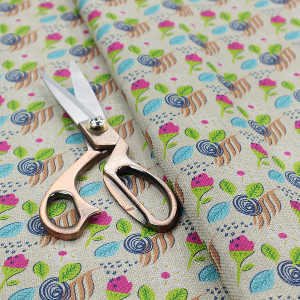 Fabric featuring a whimsical, hand-drawn botanical pattern of small pink flower buds, blue spiral circles, and bright green leaves on a light grey linen-textured background.