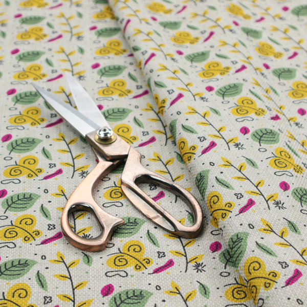 Fabric featuring a whimsical, Scandinavian-style botanical print with rows of tiny yellow butterflies, leafy green foliage, and magenta accents on a light grey linen-textured background.