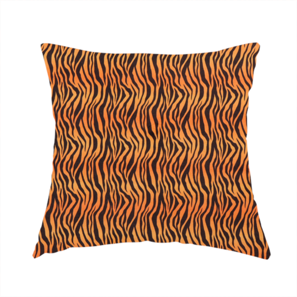 The fabric used to create this handmade cushion is a featuring a dense, repeating animal print pattern of vertical black tiger stripes over a vibrant orange background.