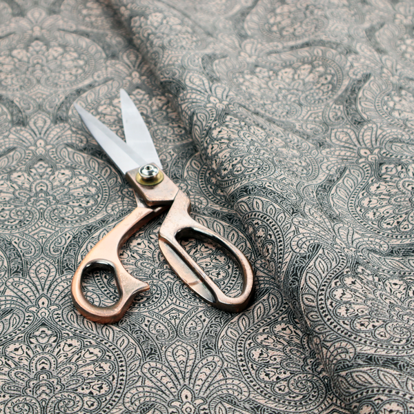 An intricate, repeating damask and paisley design on fabric, featuring elegant, symmetrical motifs.