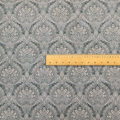 An intricate, repeating damask and paisley design on fabric, featuring elegant, symmetrical motifs.