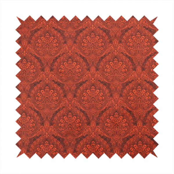 An intricate, repeating damask and paisley design on fabric, featuring elegant, symmetrical motifs.