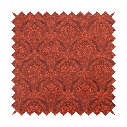 An intricate, repeating damask and paisley design on fabric, featuring elegant, symmetrical motifs.
