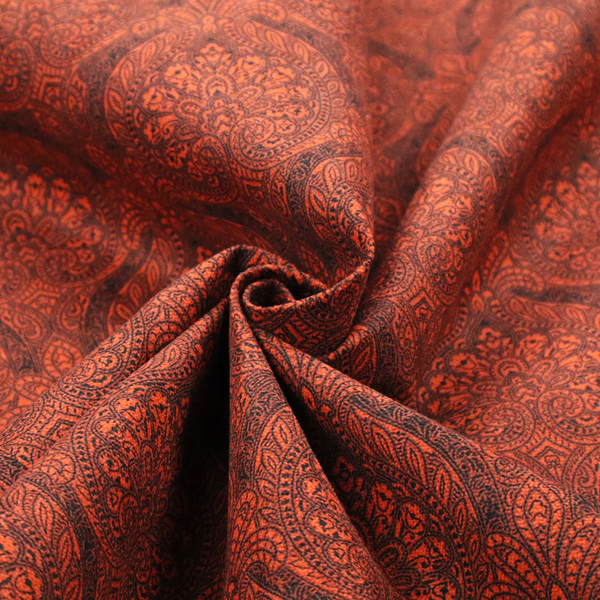An intricate, repeating damask and paisley design on fabric, featuring elegant, symmetrical motifs.