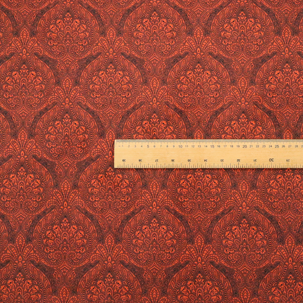 An intricate, repeating damask and paisley design on fabric, featuring elegant, symmetrical motifs.