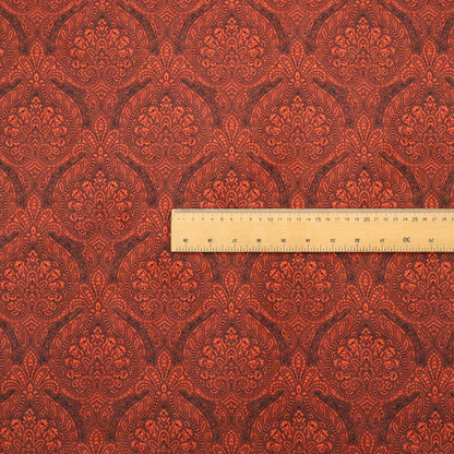 An intricate, repeating damask and paisley design on fabric, featuring elegant, symmetrical motifs.