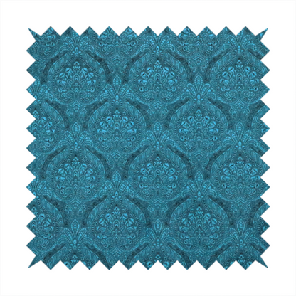 An intricate, repeating damask and paisley design on fabric, featuring elegant, symmetrical motifs.