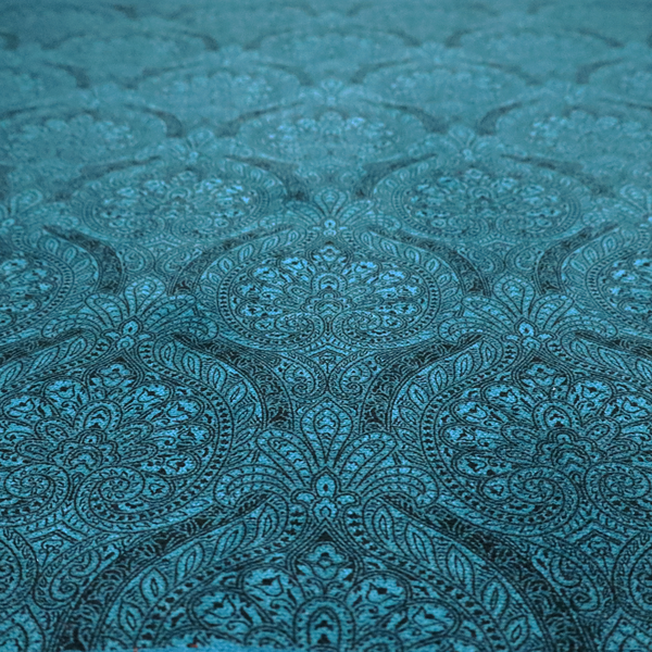 An intricate, repeating damask and paisley design on fabric, featuring elegant, symmetrical motifs.