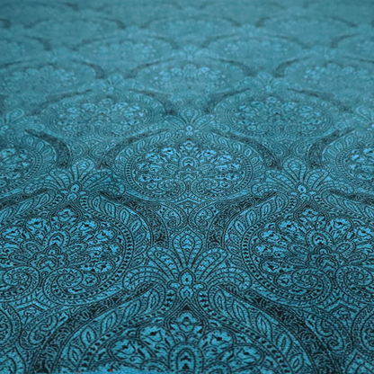 An intricate, repeating damask and paisley design on fabric, featuring elegant, symmetrical motifs.