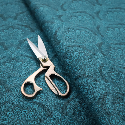 An intricate, repeating damask and paisley design on fabric, featuring elegant, symmetrical motifs.