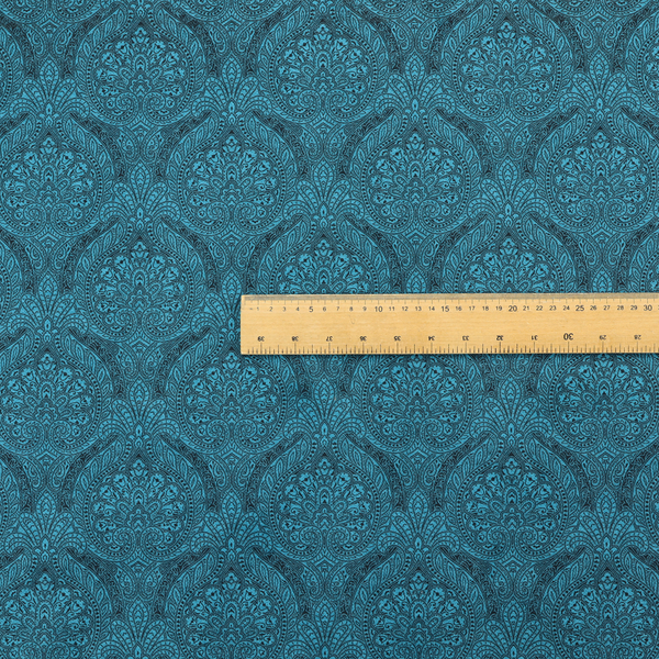 An intricate, repeating damask and paisley design on fabric, featuring elegant, symmetrical motifs.