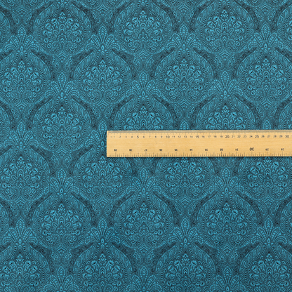 An intricate, repeating damask and paisley design on fabric, featuring elegant, symmetrical motifs.
