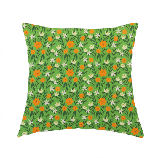 The fabric used to create these handmade cushions is a bright green fabric featuring a dense, repeating pattern of small orange flowers, delicate white blossoms, and dark green leaves.