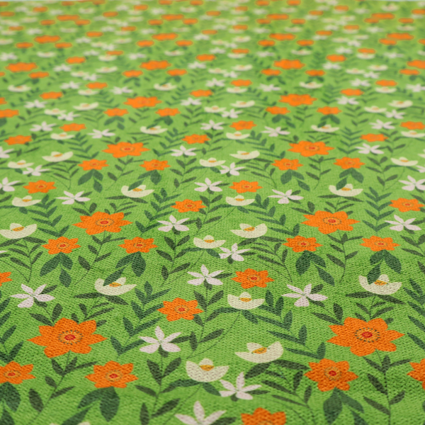 A bright green fabric featuring a dense, repeating pattern of small orange flowers, delicate white blossoms, and dark green leaves.