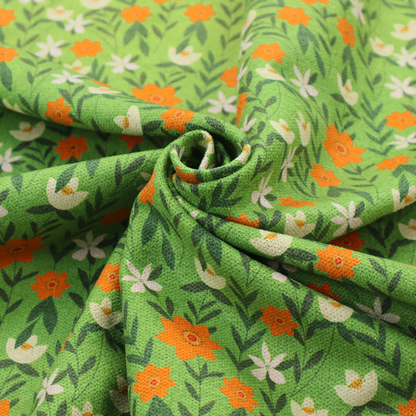 A bright green fabric featuring a dense, repeating pattern of small orange flowers, delicate white blossoms, and dark green leaves.