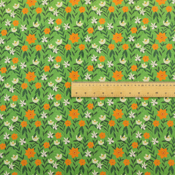 A bright green fabric featuring a dense, repeating pattern of small orange flowers, delicate white blossoms, and dark green leaves.