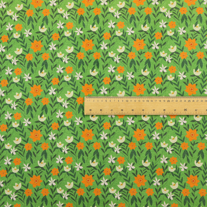 A bright green fabric featuring a dense, repeating pattern of small orange flowers, delicate white blossoms, and dark green leaves.