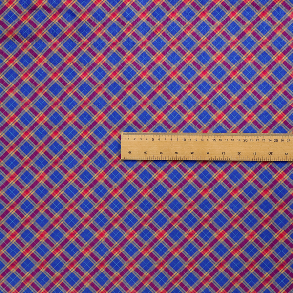 Vibrant blue and red diamond plaid fabric featuring an intricate diagonal checked pattern with intersecting lines in rich royal blue, bright red, and yellow highlights.