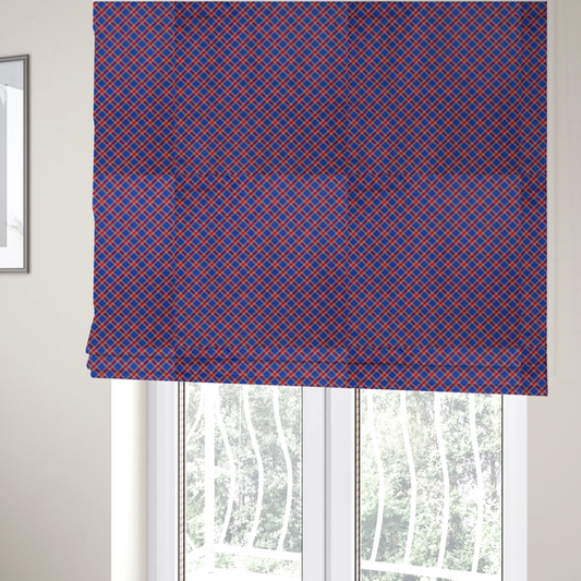 The fabric used to create these Roman blinds is a vibrant blue and red diamond plaid fabric featuring an intricate diagonal checked pattern with intersecting lines in rich royal blue, bright red, and yellow highlights.