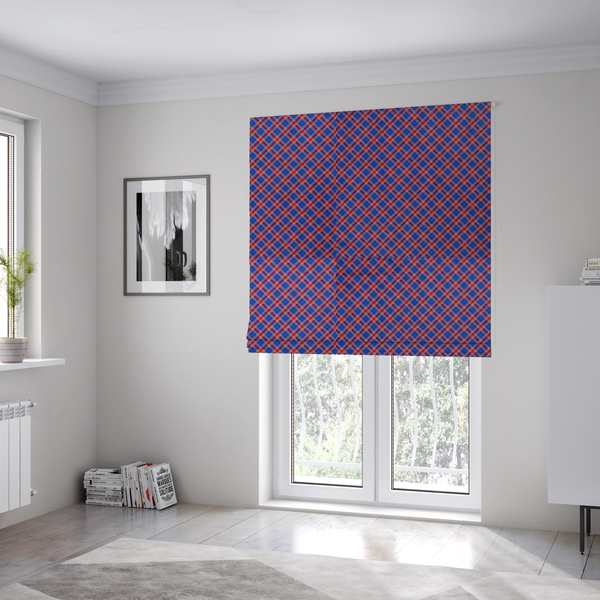 The fabric used to create these Roman blinds is a vibrant blue and red diamond plaid fabric featuring an intricate diagonal checked pattern with intersecting lines in rich royal blue, bright red, and yellow highlights.