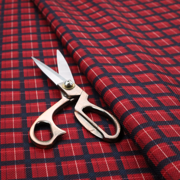 Bold red and navy plaid fabric featuring a structured checked pattern with prominent dark navy grids, vibrant red blocks, and subtle white pin lines.