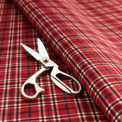 Classic red and black tartan plaid fabric featuring a traditional checked pattern with intersecting lines in rich red, dark black, and subtle white highlights.