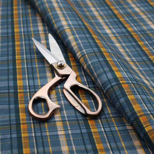 Blue and gold plaid fabric featuring a structured checked pattern with intersecting lines in muted slate blue, deep navy, vibrant gold, and crisp white pin lines.