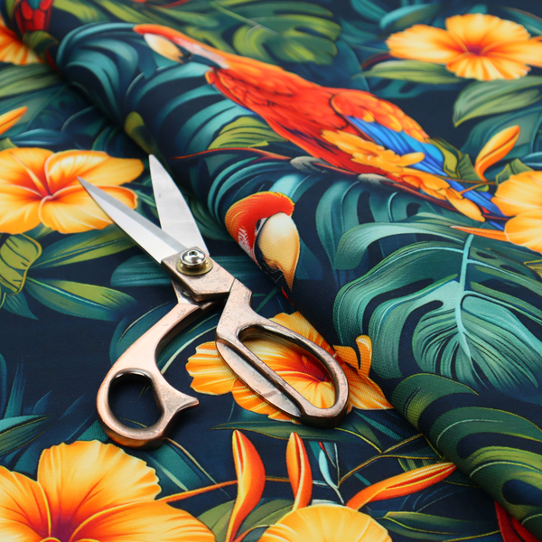 A tropical jungle print featuring vibrant red and yellow macaws perched amidst large green monstera leaves and bright yellow hibiscus flowers.