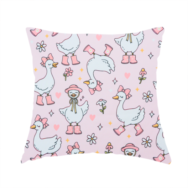 The fabric used to create this handmade cushion is a cute, whimsical cartoon print featuring white geese wearing pink rain boots and matching pink hats or bows, interspersed with small flowers, hearts, and sparkles.