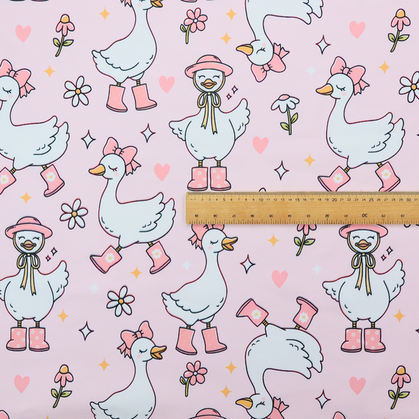 A cute, whimsical cartoon print featuring white geese wearing pink rain boots and matching pink hats or bows, interspersed with small flowers, hearts, and sparkles.