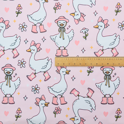 A cute, whimsical cartoon print featuring white geese wearing pink rain boots and matching pink hats or bows, interspersed with small flowers, hearts, and sparkles.