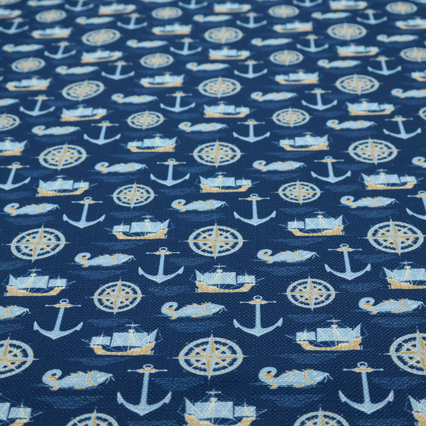 A nautical-themed fabric pattern featuring alternating rows of light blue and gold sailing ships, compass roses, anchors, and fish against a dark blue background.