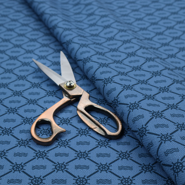 A nautical-themed fabric pattern featuring a repeating navy blue geometric grid of ship's wheels and small wavy lines against a medium blue background.