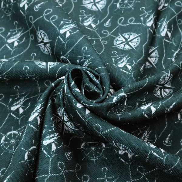 A nautical-themed fabric pattern featuring light blue compass roses, ships, anchors, and intertwined ropes against a dark teal or green background.