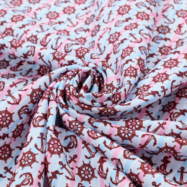 A nautical-themed fabric pattern featuring diagonal stripes in light blue and pink, scattered with dark red ship's wheels and anchors.