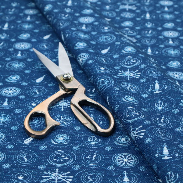 A nautical-themed fabric pattern featuring an all-over small-scale print of white ship's wheels, anchors, compass roses, and nautical motifs against a textured dark blue background.