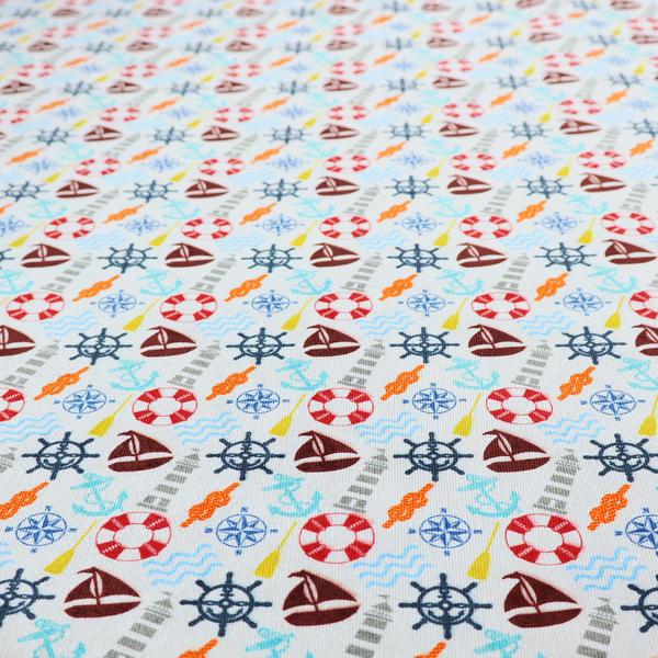 A colourful nautical-themed fabric pattern featuring a repeating mix of lighthouses, sailboats, life rings, ship's wheels, anchors, and waves against a white background.