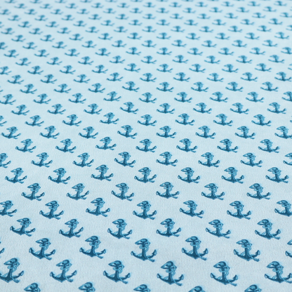 A nautical-themed fabric pattern featuring a repeating print of dark blue anchors against a light blue background.