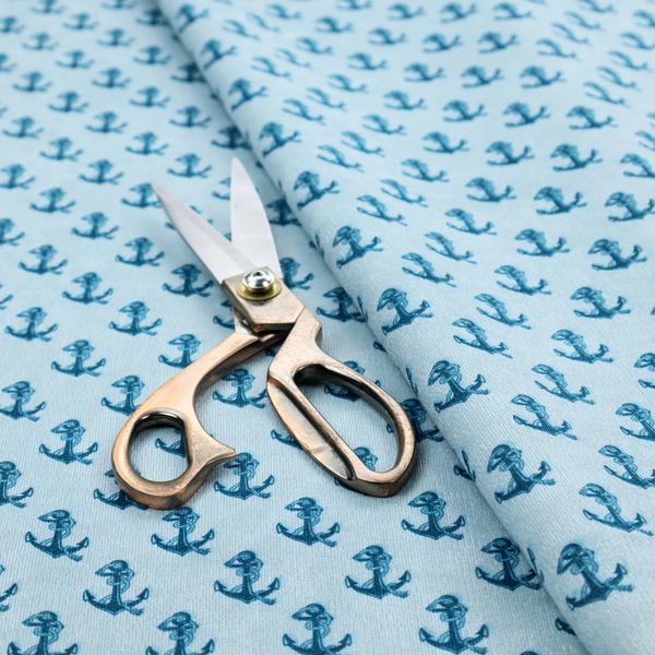 A nautical-themed fabric pattern featuring a repeating print of dark blue anchors against a light blue background.
