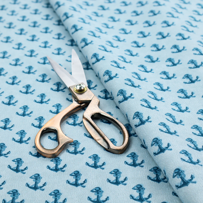 A nautical-themed fabric pattern featuring a repeating print of dark blue anchors against a light blue background.